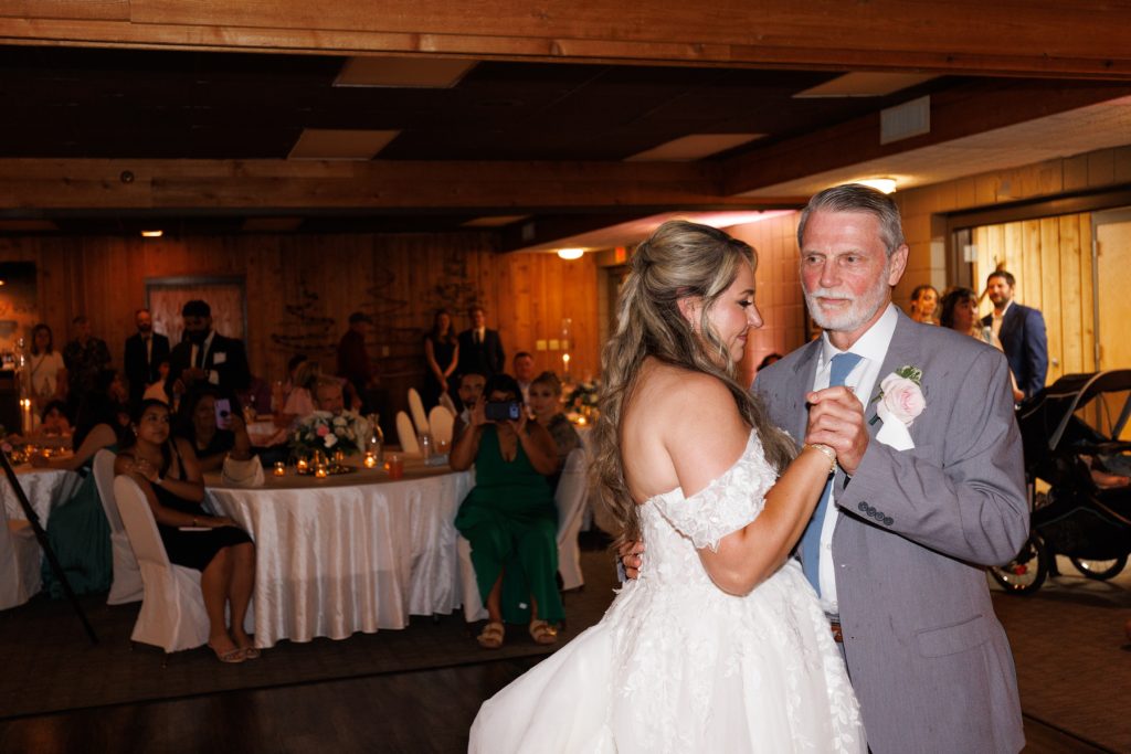 Bride and groom share a tender dance with her father at a Lakewoods Resort wedding