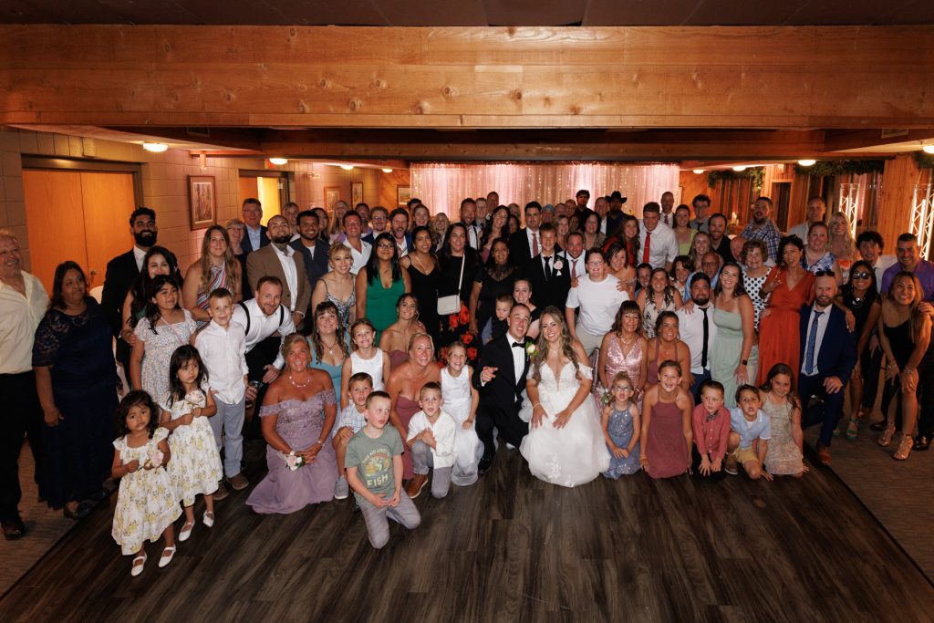 Large group wedding photograph featuring Bianca and Nick at Lakewoods Resort in Cable, Wisconsin, surrounded