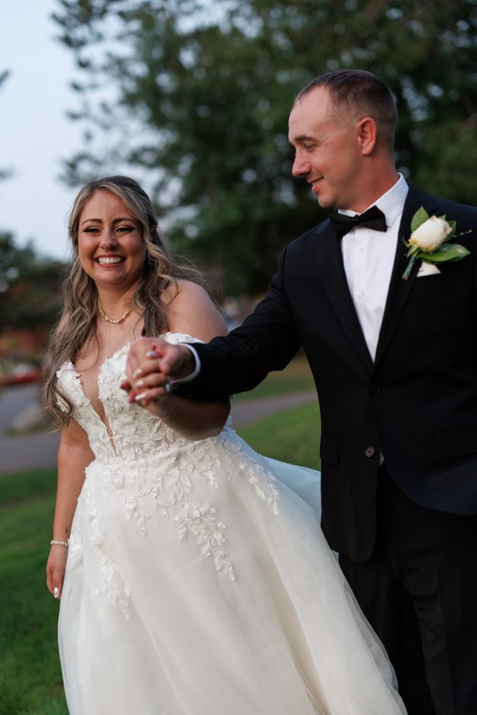 Bianca and Nick, the happy couple, hold hands during their destination wedding at Lakewoods Resort