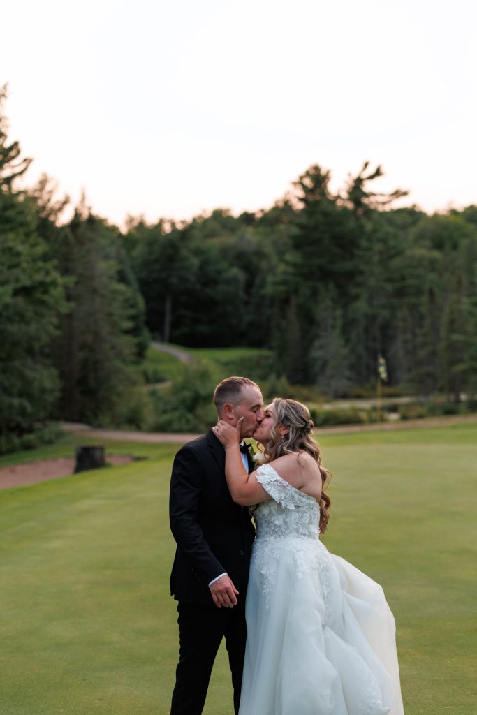 Bianca and Nick share a romantic kiss during their destination wedding at Lakewoods Resort
