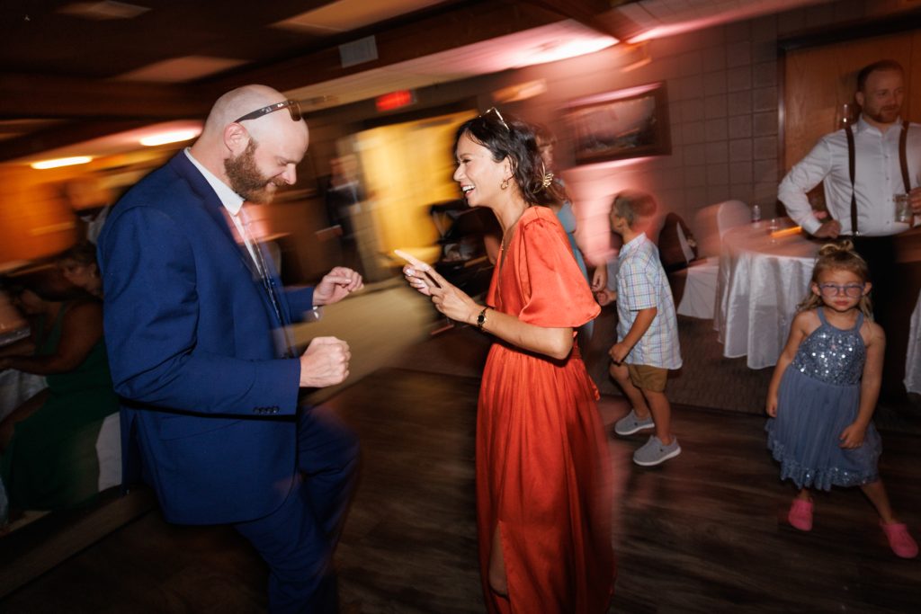 Bride and groom dancing joyfully at their Lakewoods Resort wedding reception in Cable, Wisconsin, captured