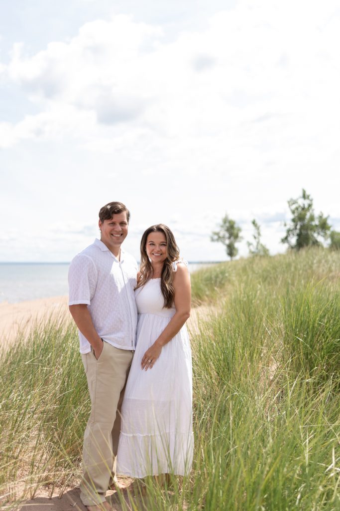 Cassie and Daniel, the engaged couple, smiling together during their engagement session near Lake Superior