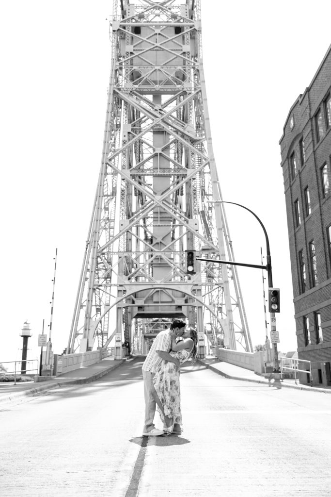 Cassie and Daniel embrace during their engagement session near the Duluth Aerial Lift Bridge, showcasing
