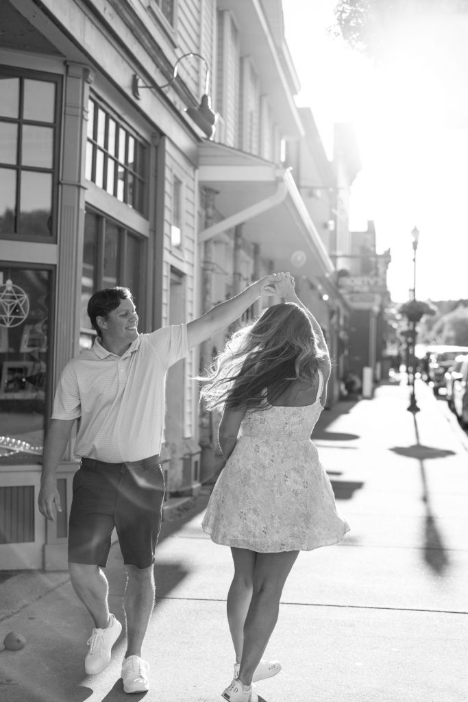 Cassie and Daniel joyfully dancing during their engagement session in Bayfield, Minnesota, captured by Beau